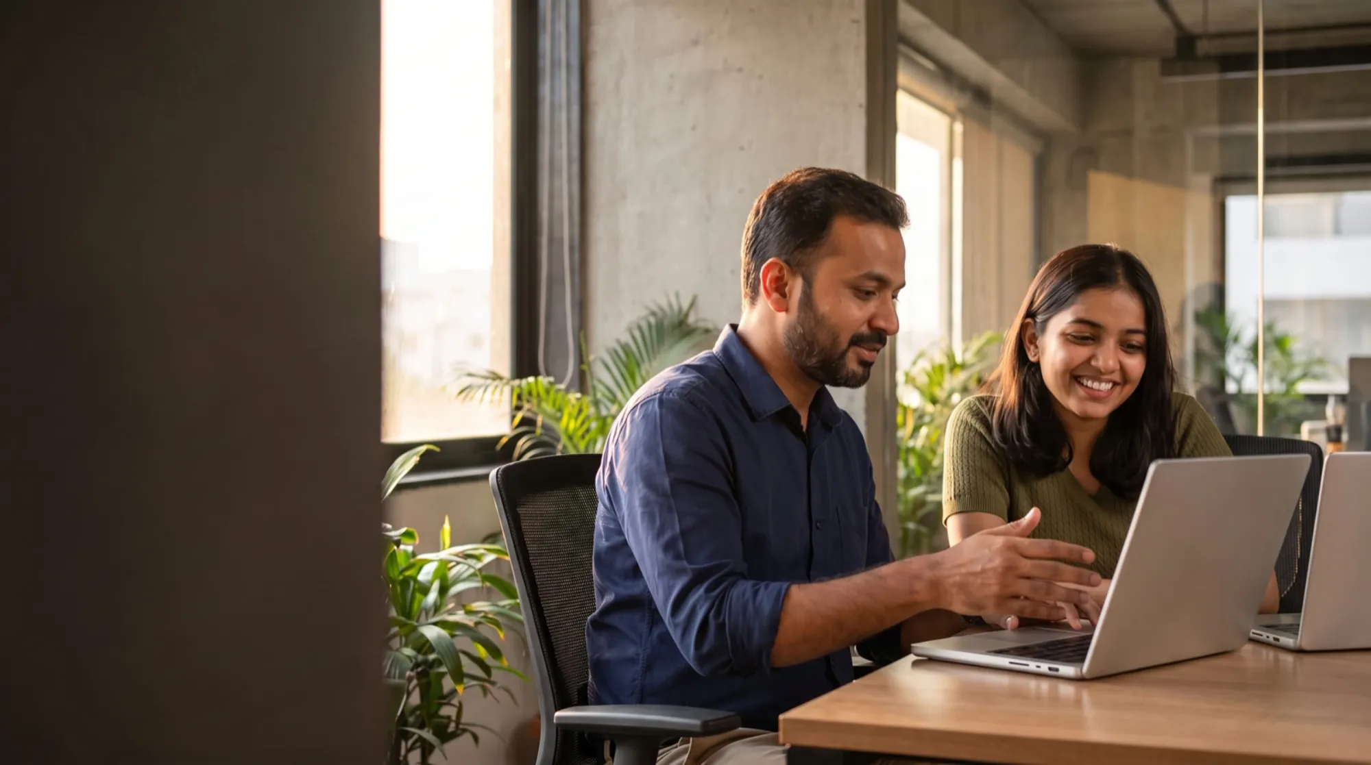 A mentor and a student working together at a laptop
